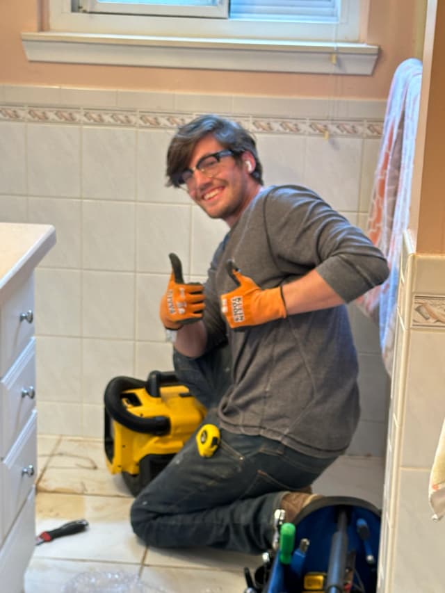 Toilet Guys technician giving thumbs up during a toilet installation in Milford, MI