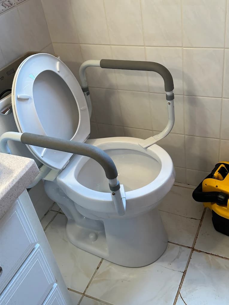 Comfort height toilet with safety grab rails installed — ADA-compliant toilet installation in Milford